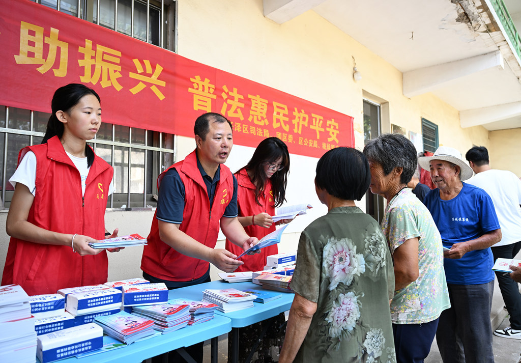8月3日，邢台市任泽区司法局工作人员在任城镇小官庄社区向居民发放普法手册。