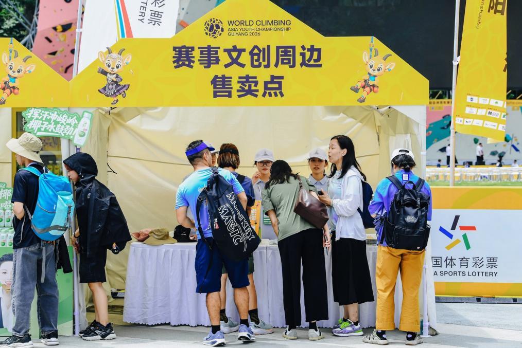 （中外游客在市集文创摊位前挑选商品）