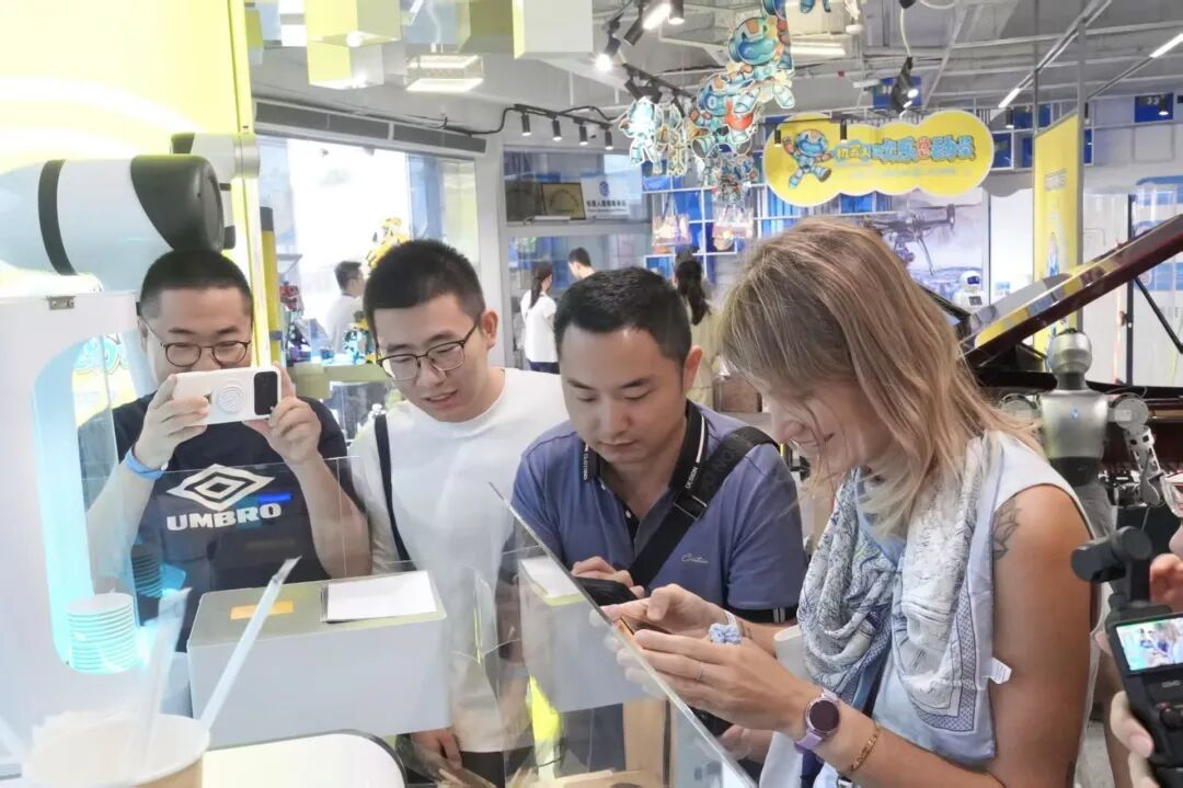 外国友人正在围观咖啡机器人制作咖啡。(叶惠玲 摄)