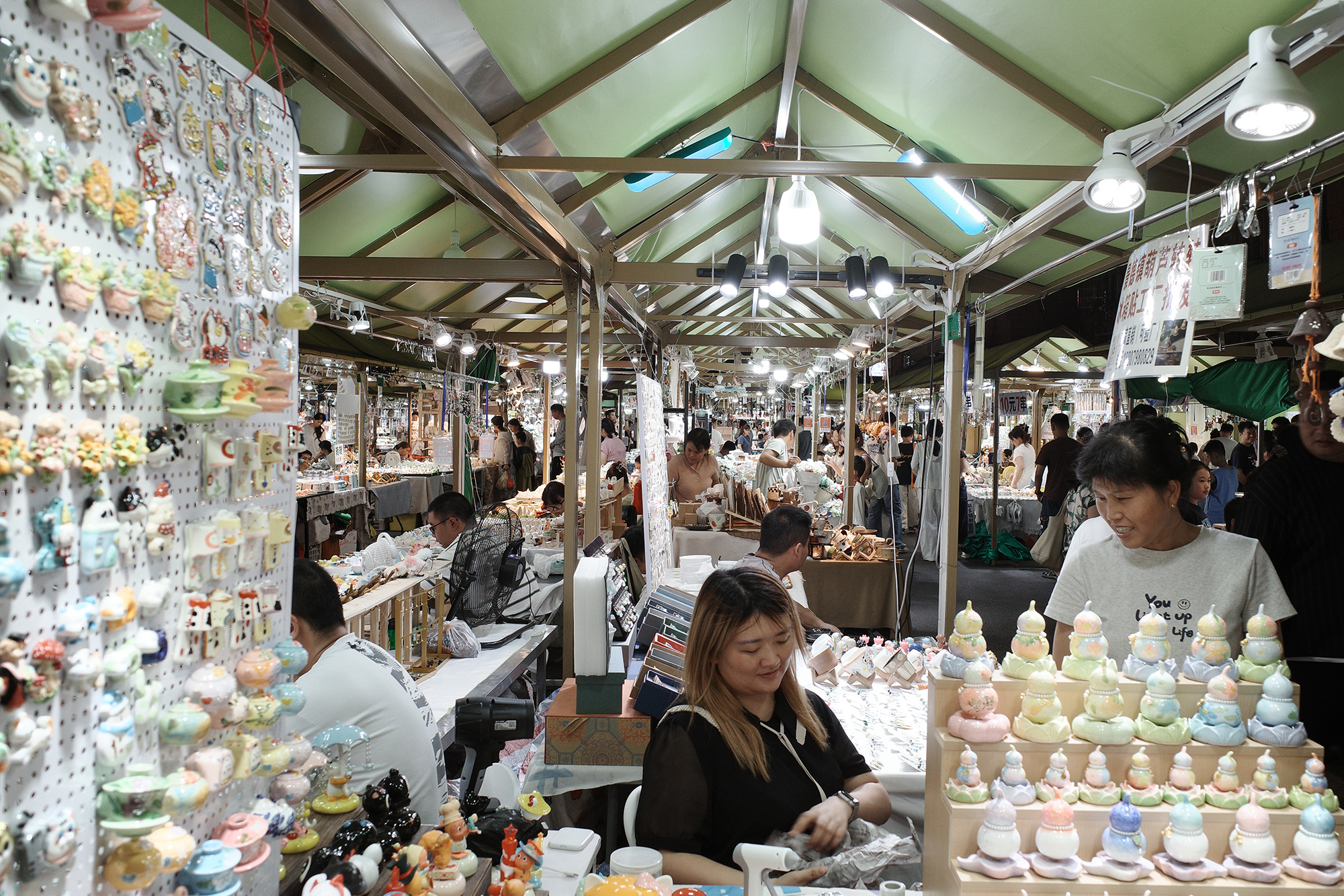 ▲8月25日，游客在童宾市集购买文创产品。