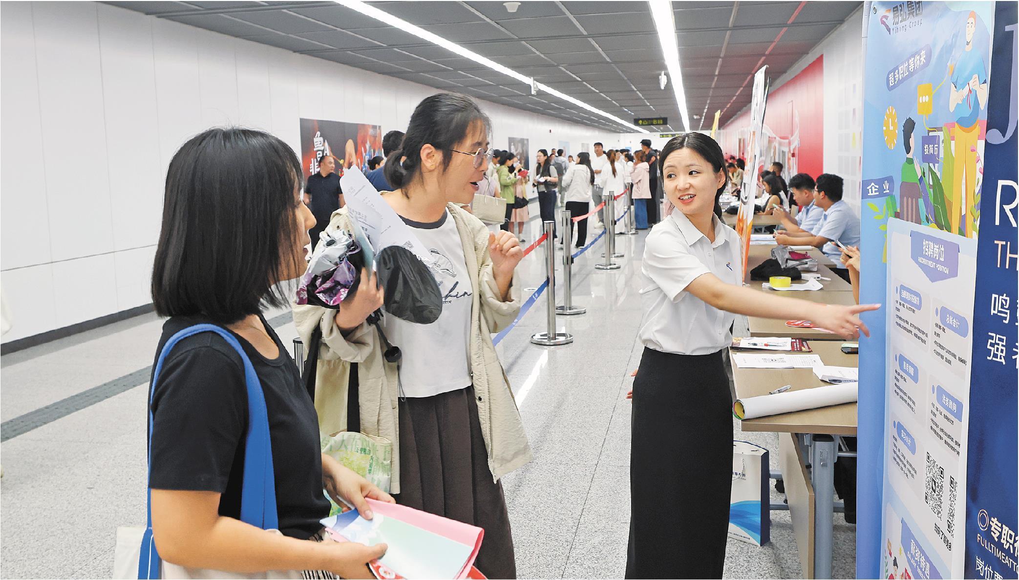 8月28日，招聘企业工作人员在济南汉峪金谷地铁站回答求职者咨询。（□记者卢鹏实习生马广泽报道）