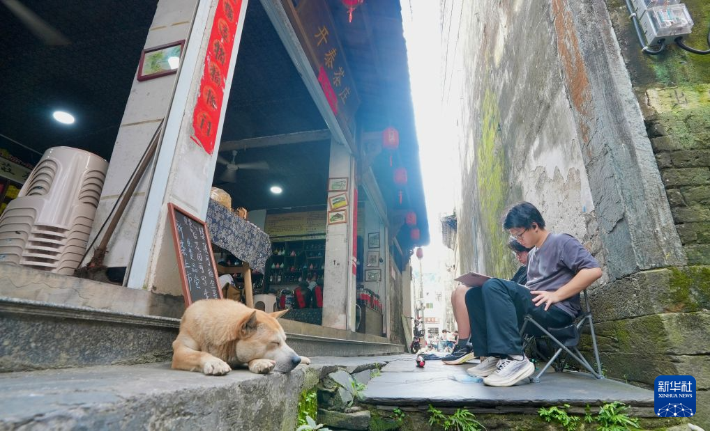 8月25日，游客在理坑村古巷内写生。