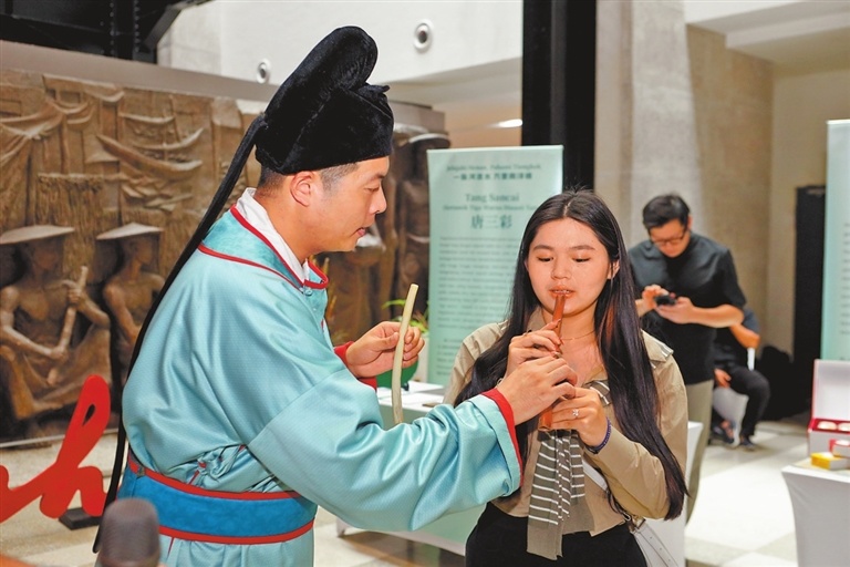 当地市民体验吹奏贾湖骨笛。