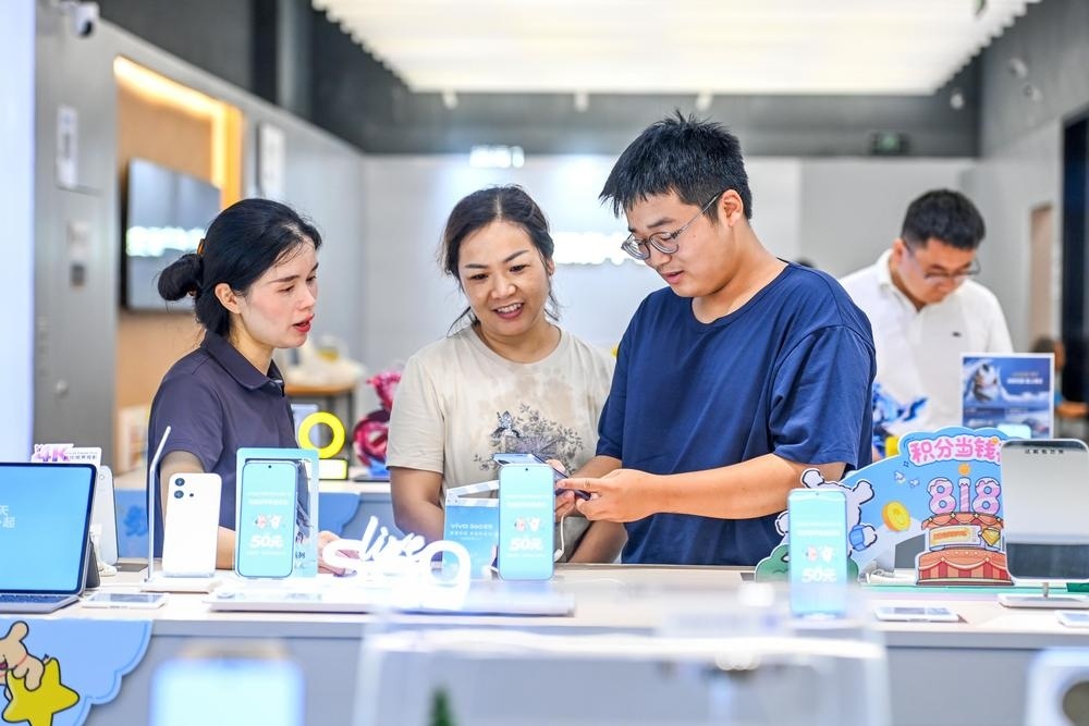 宜春中心城区万达广场某数码产品店内,家长带着即将开学的孩子选购电子产品。 (记者 周 亮 摄)