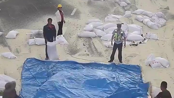 300多袋大米散落一地，一群人冒雨围上来