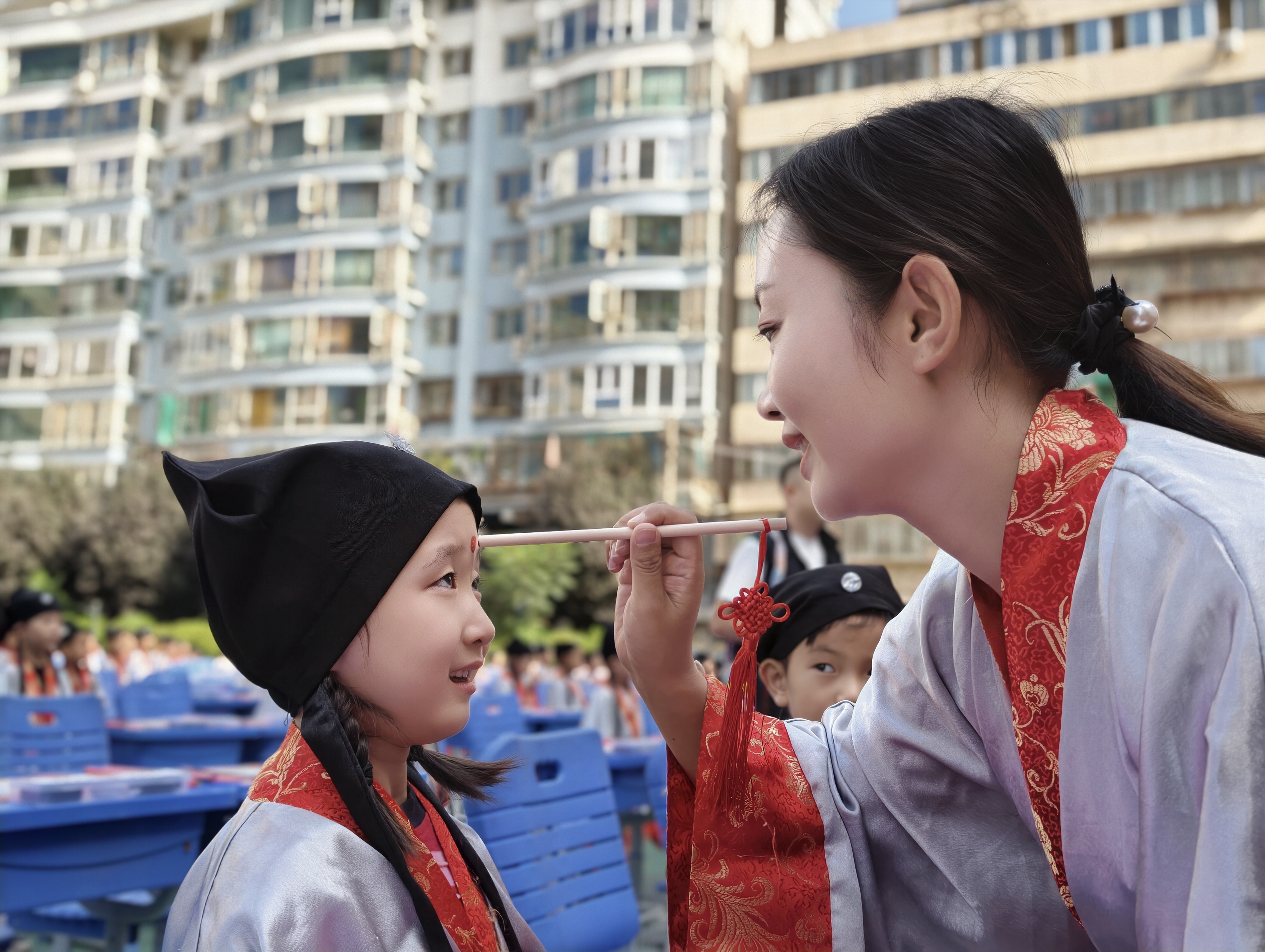 老师手持毛笔给孩子们额头轻点朱砂