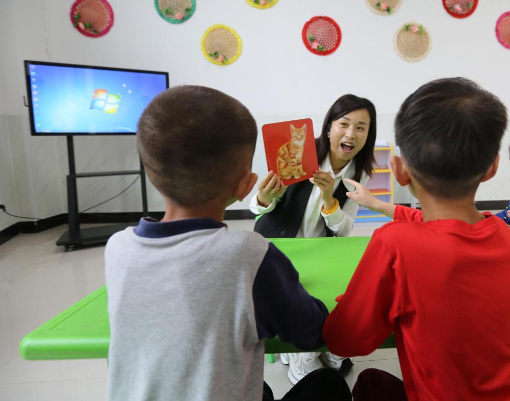 甘肃省定西市特殊教育学校学前部的老师正在给小朋友上课　新华社发（王克贤　摄）