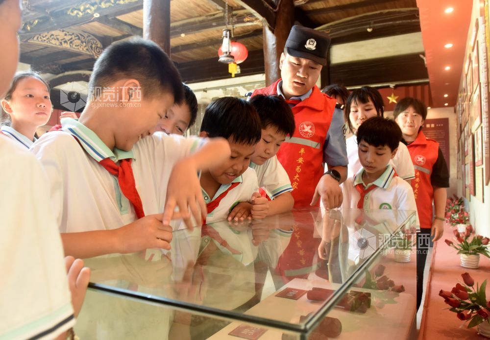 2026年9月1日,在江西景德镇市乐平市众埠镇界首村“中国工农红军第十军建军旧址”内,乐平市公安局众埠派出所“红色义警”民警彭星磊正对照旧址内的展示物品等,给该村小学6年级的学生开展“入学第一课”教育。