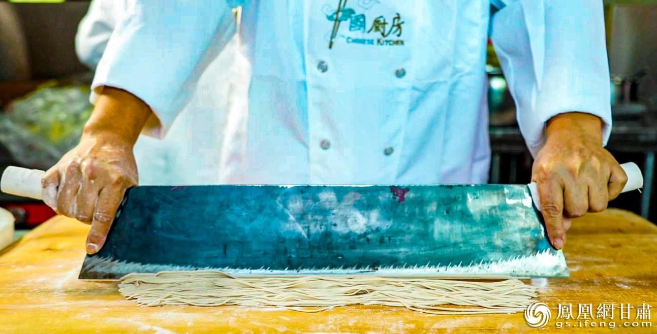 厨师双手持特制双柄刀，将醒好的荞面快速剁成均匀细条。图源自华池县人民政府官网