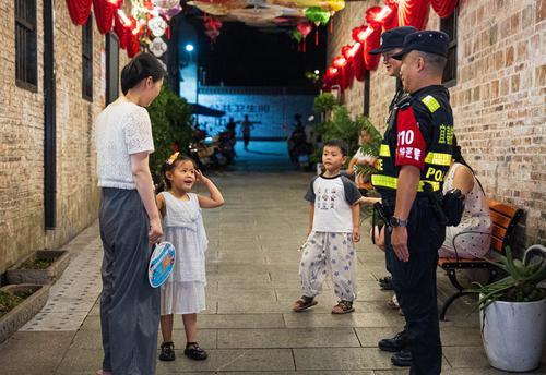稚童向街巷夜巡的特巡警敬礼