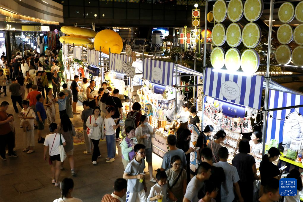 7月25日晚,人们在江苏常州文化广场“苏超”比赛观赛点的特色集市上休闲购物。新华社发(陈暐 摄)