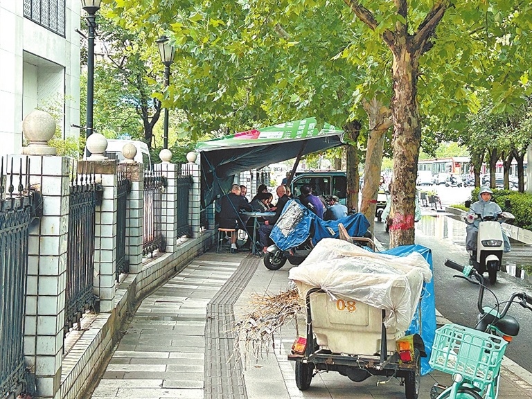 未来路上,有人在盲道上搭起帐篷,支起桌椅打麻将。