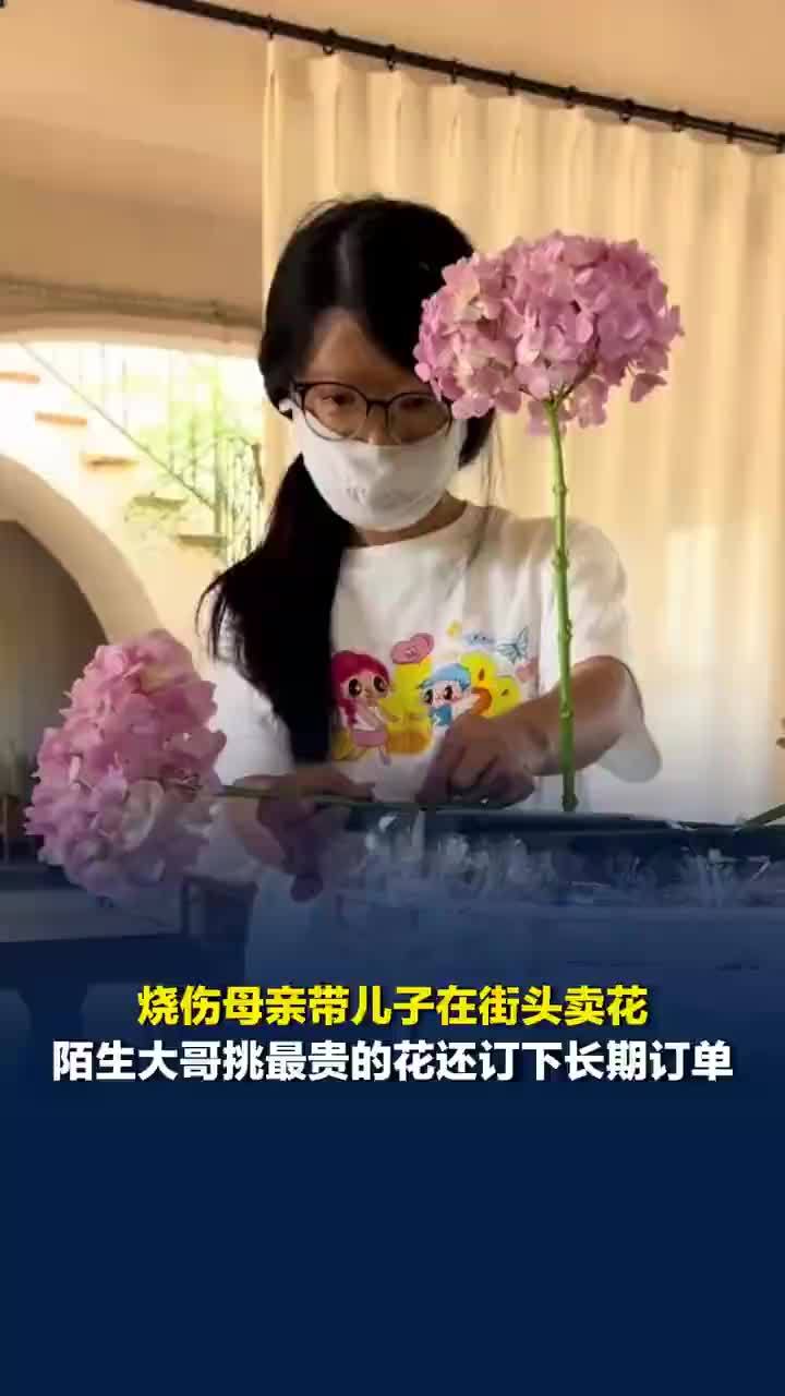 烧伤母亲带娃卖花大哥订下长期订单，烧伤母亲带娃街头卖花大哥买给老婆