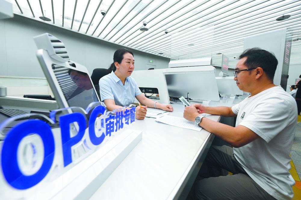 在石家庄市政务服务中心OPC审批专区，工作人员为企业负责人讲解OPC登记相关政策和办理流程。
