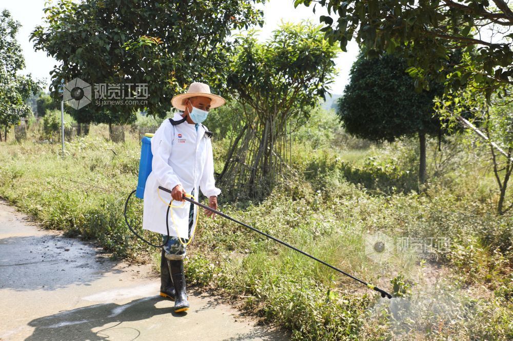 峡江县水边镇黄家村,消杀人员对户外区域消毒作业。