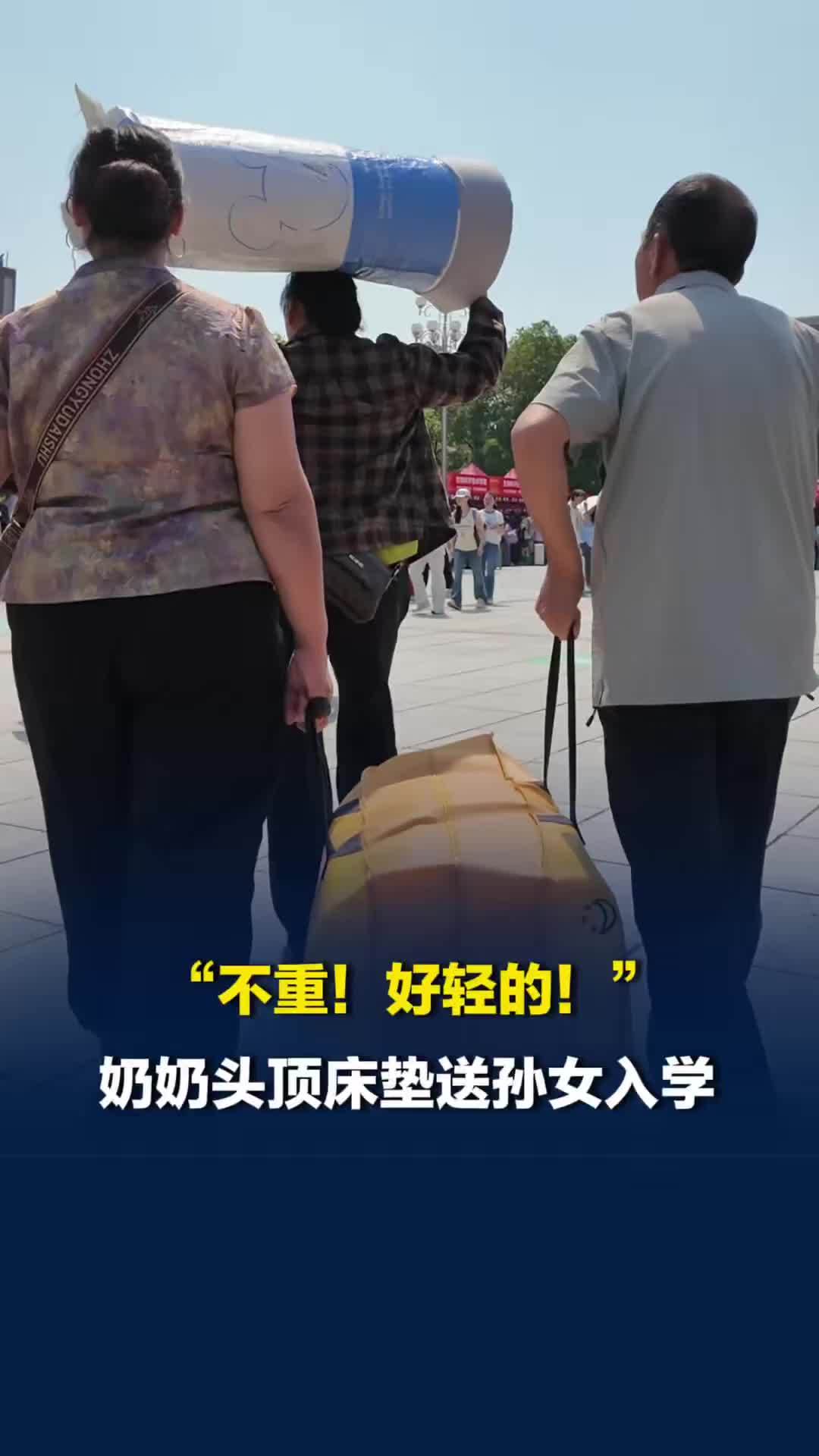 “不重，好轻的！”奶奶头顶着床垫送孙女入学
