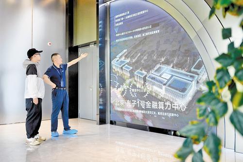9月4日,光子1号金融算力中心工作人员(右)向客户介绍运营情况。 目前,该金融算力中心投用标准机柜4500架,可提供1500P算力,是我省唯一以金融级区块链立项的算力中心项目。本报记者 王伟摄