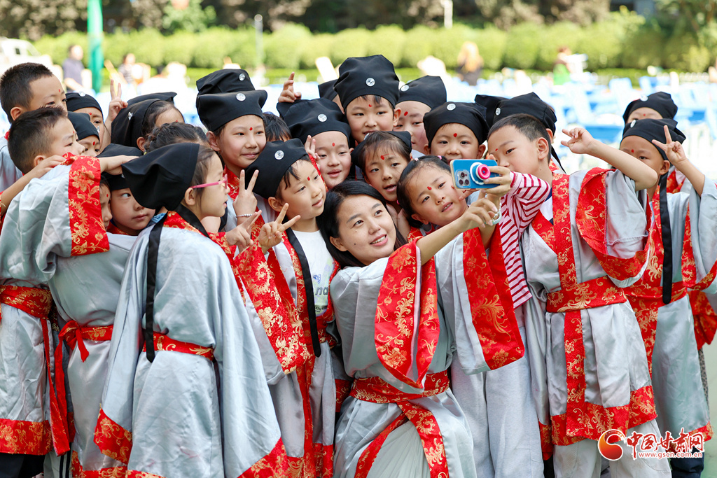9月4日,在兰州市七里河区七里河小学“开笔礼”仪式上,一年级新生和老师合影留念。