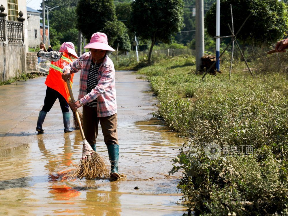 峡江县水边镇黄家村,保洁人员清扫路面淤泥。
