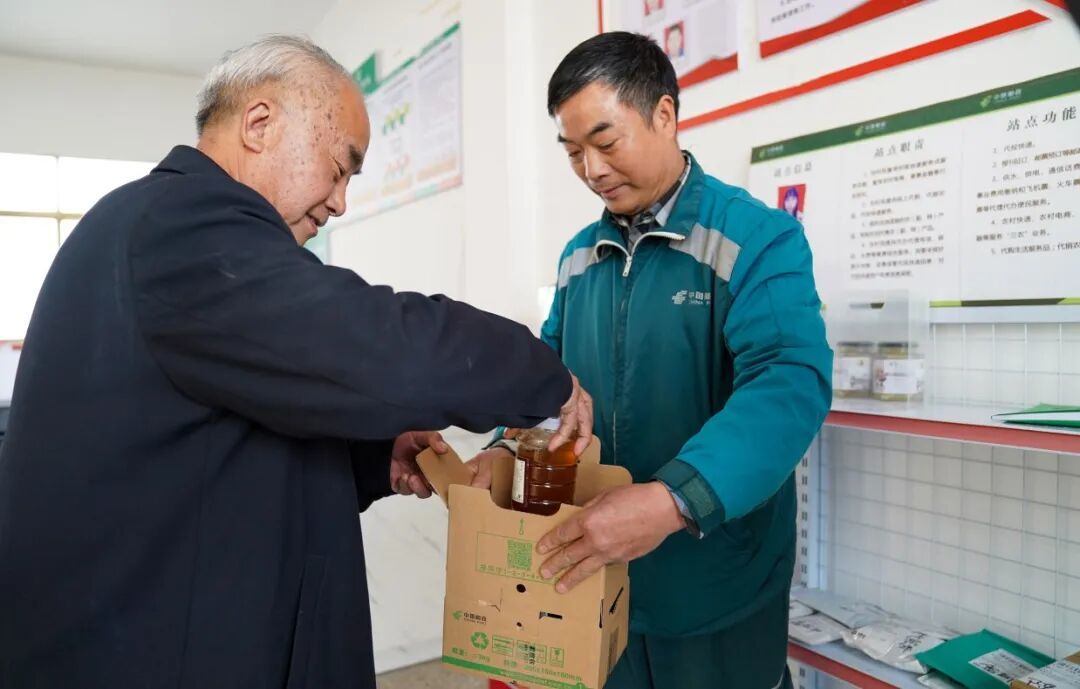渝水区良山镇鹊桥村,快递员在兴村快递综合服务点揽收快递。记者谭建荣 摄