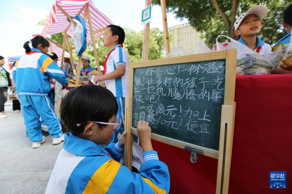 9月11日，公园路小学学生在义卖现场布置摊位。新华社发（王克贤　摄）