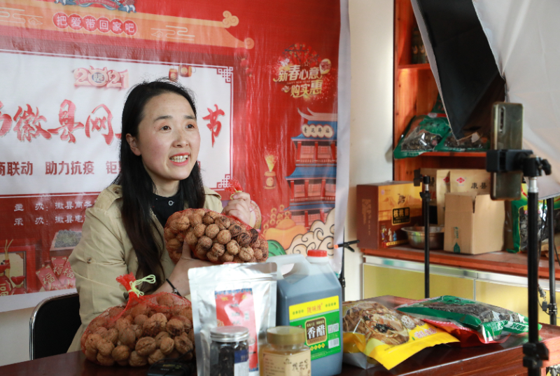 在位于甘肃陇南市徽县的店铺中,主播梁倩娟在网上直播销售当地农特产品。新华社记者 张智敏 摄