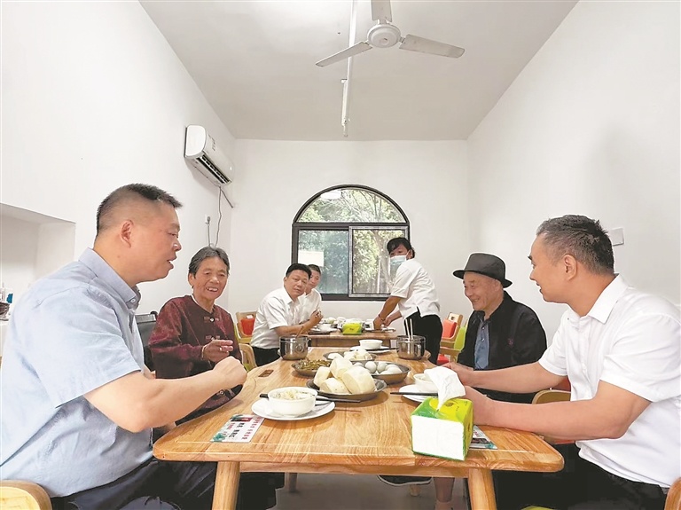 南昌市民政局局长戴闽(左一)在南昌市新建区联圩敬老院陪老人用餐。