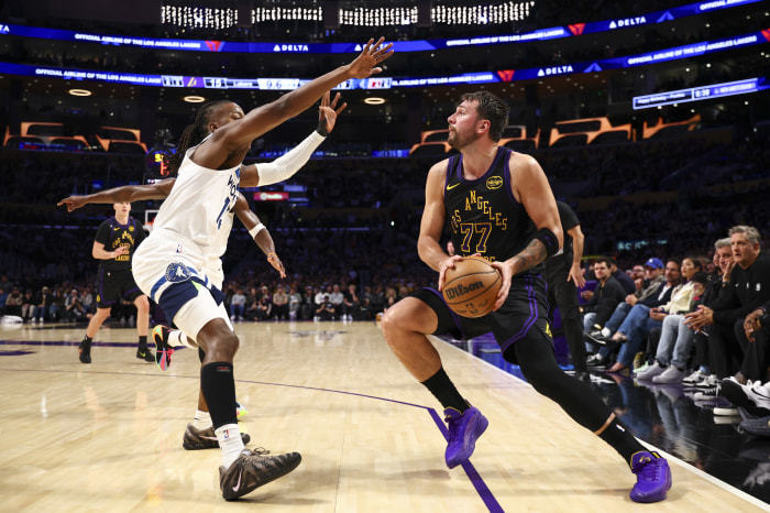Luka Doncic (77) of the Los Angeles Lakers handles the ball against Ayo Dosunmu (13) of the Minnesota Timberwolves.