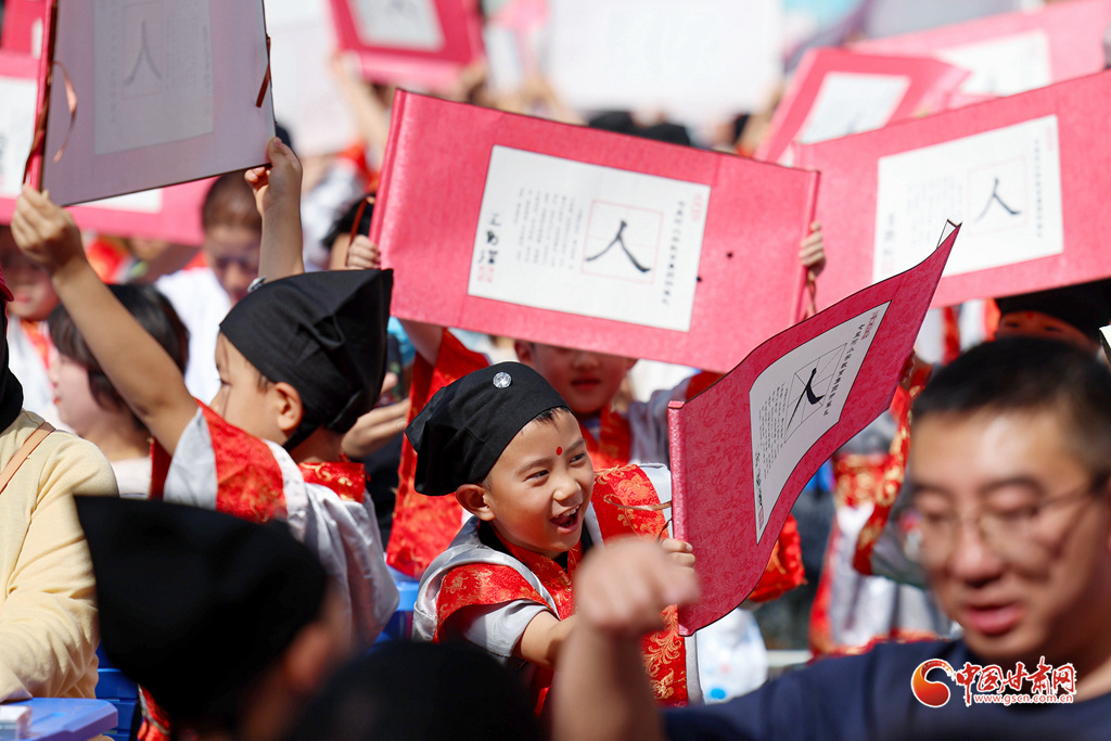 9月4日,在兰州市七里河区七里河小学“开笔礼”仪式上,一年级新生高举自己和家长共同书写的“人”字牌。