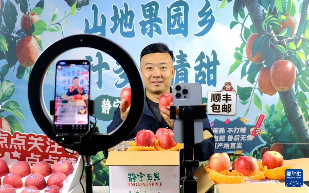 9月8日,在甘肃省平凉市静宁县工业园区的一家果品企业里,网络主播推介静宁苹果。新华社发(王毅 摄)