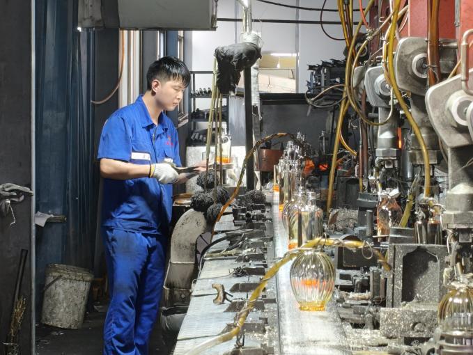 正在“叨瓶子”的工人。唐泽楷图