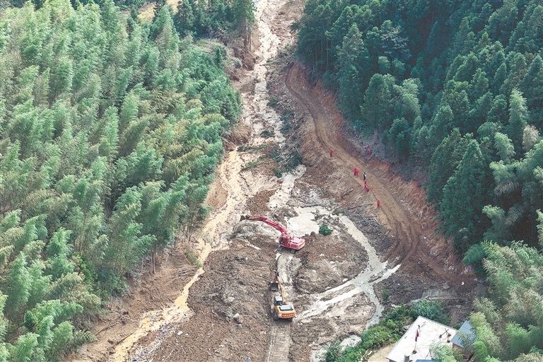9月6日23时，通往遂川县高坪镇明坑村石下组核心救援现场的600米关键道路，历经15小时抢修，终于抢通。图为9月7日，中国安能救援施工人员正在修整路面。江西日报全媒体记者 洪子波摄