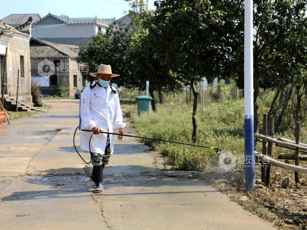 峡江县水边镇黄家村,消杀人员对户外区域消毒作业。
