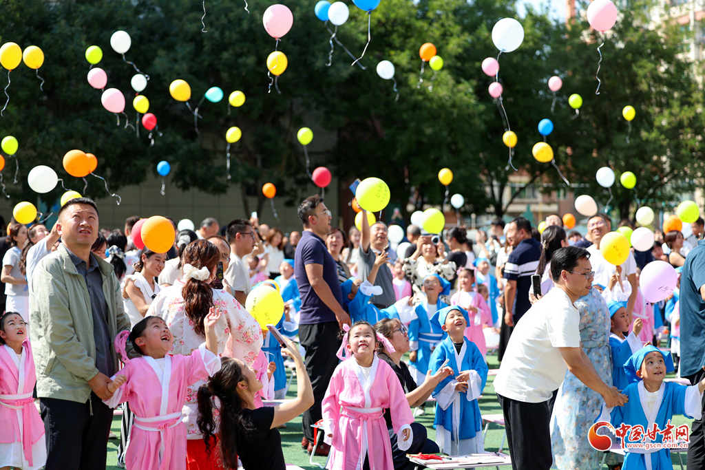 9月4日,在兰州市城关区华侨实验学校“开笔礼”仪式上,一年级新生和家长放飞书写梦想的气球。