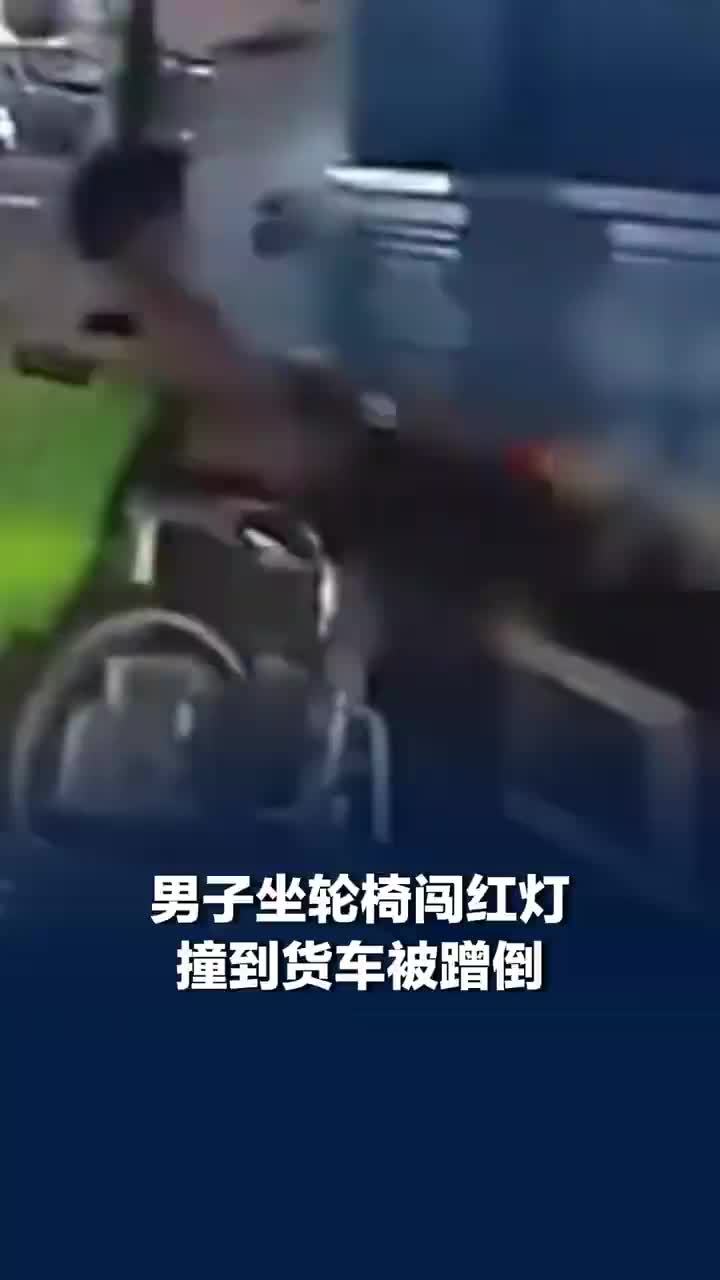 男子坐轮椅闯红灯撞到货车被蹭倒，男子不顾车流闯红灯路中间过马路