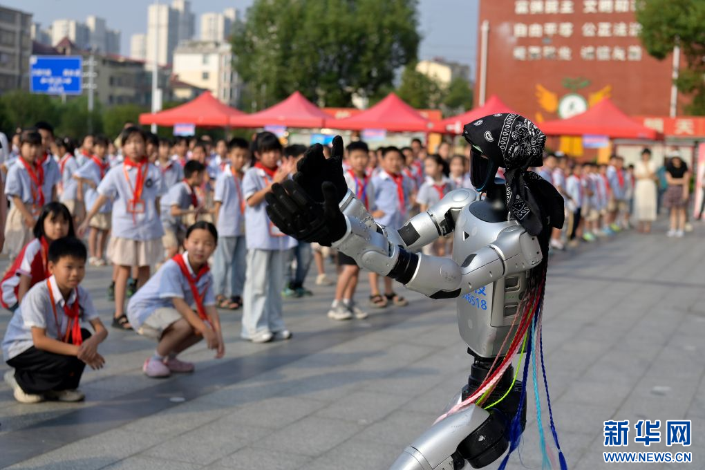9月16日,在江西省宜春市万载县康乐街道中心小学,学生们在观看机器人表演舞蹈。新华网发 邓龙华 摄