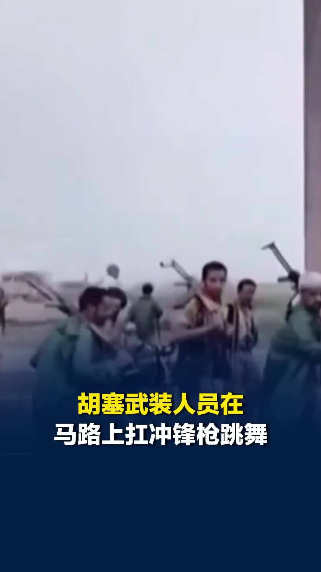 胡塞武装人员在马路上扛冲锋枪跳舞，庆祝攻下战略要地