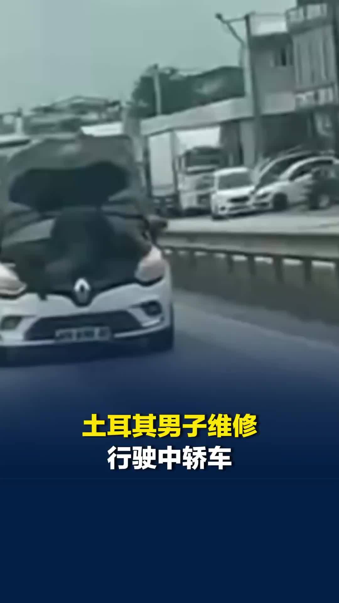 土耳其男子维修行驶中轿车：汽车发动机盖被掀开，男子趴在引擎上检修