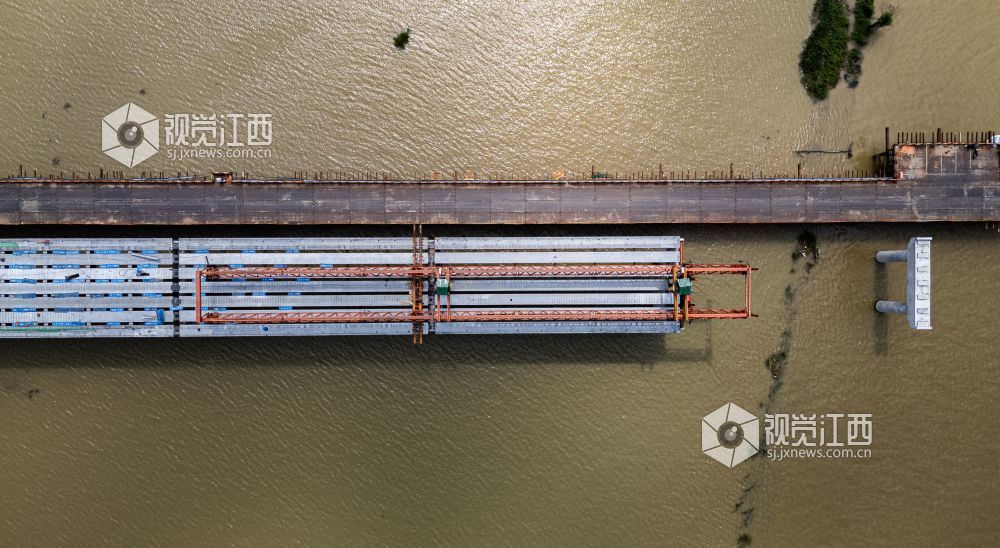赣江碧波之上,西沙埠赣江大桥主桥与两岸连接线全貌尽收眼底,施工栈桥横贯江面,现场作业有序推进。