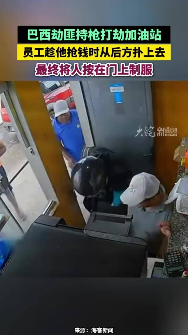 巴西劫匪持枪打劫加油站，员工趁他抢钱时从后方扑上去，最终将人按在门上制服#巴西劫匪持枪打劫加油站
