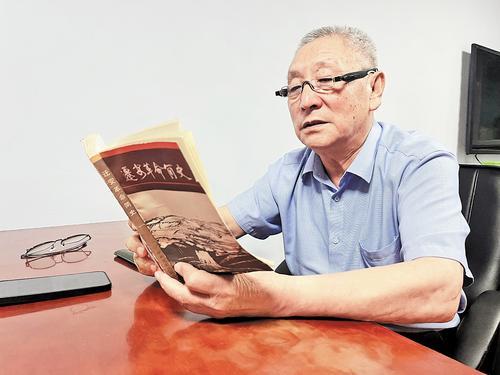 9月4日,邢立明正在翻阅书籍,寻找一位牺牲在承德的烈士信息。闫立辉摄