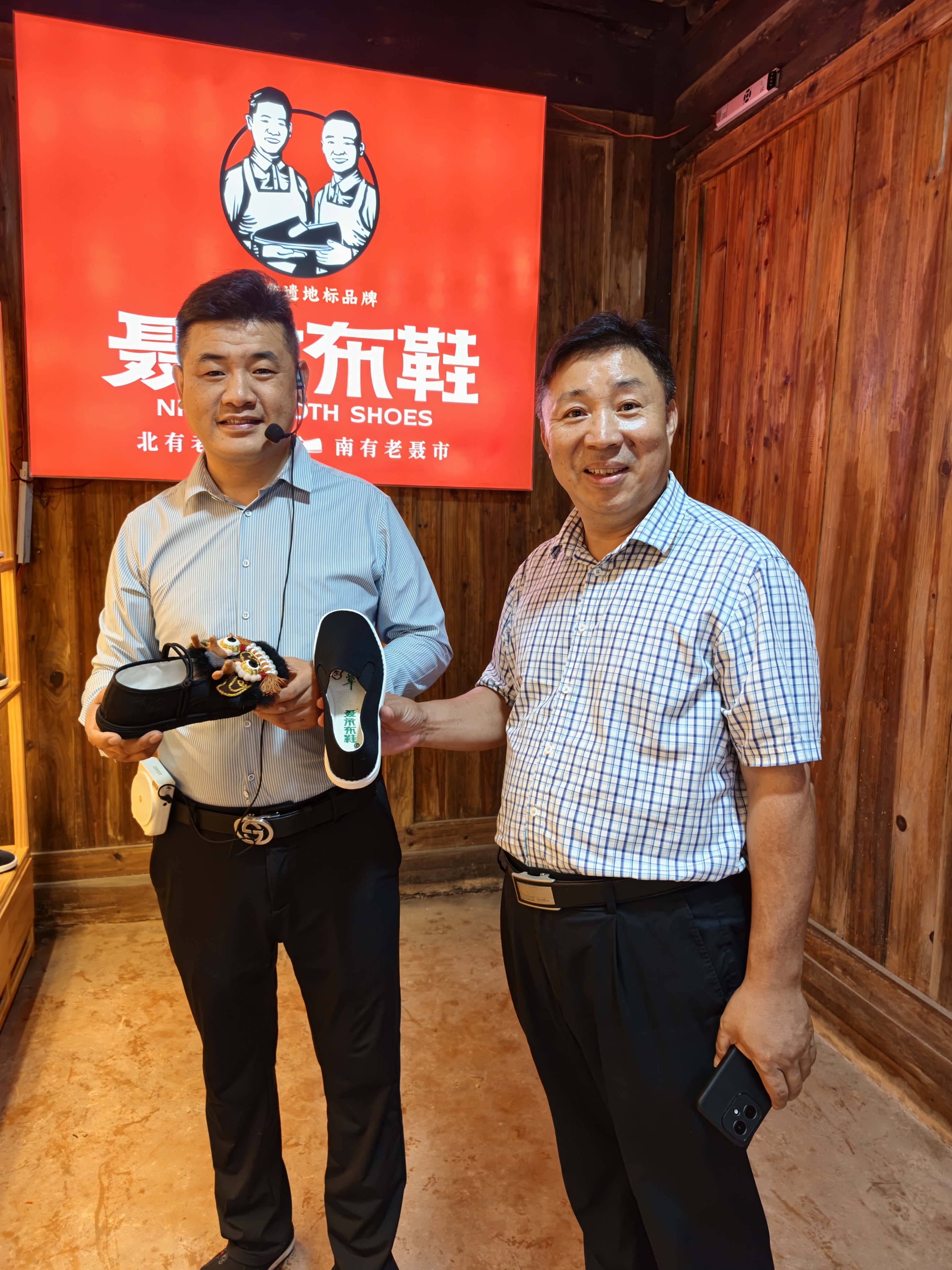 图为:凤凰网湖南频道副总经理向慕林(右)与临湘古松鞋业有限公司负责人杨小波畅聊聂市布鞋的故事