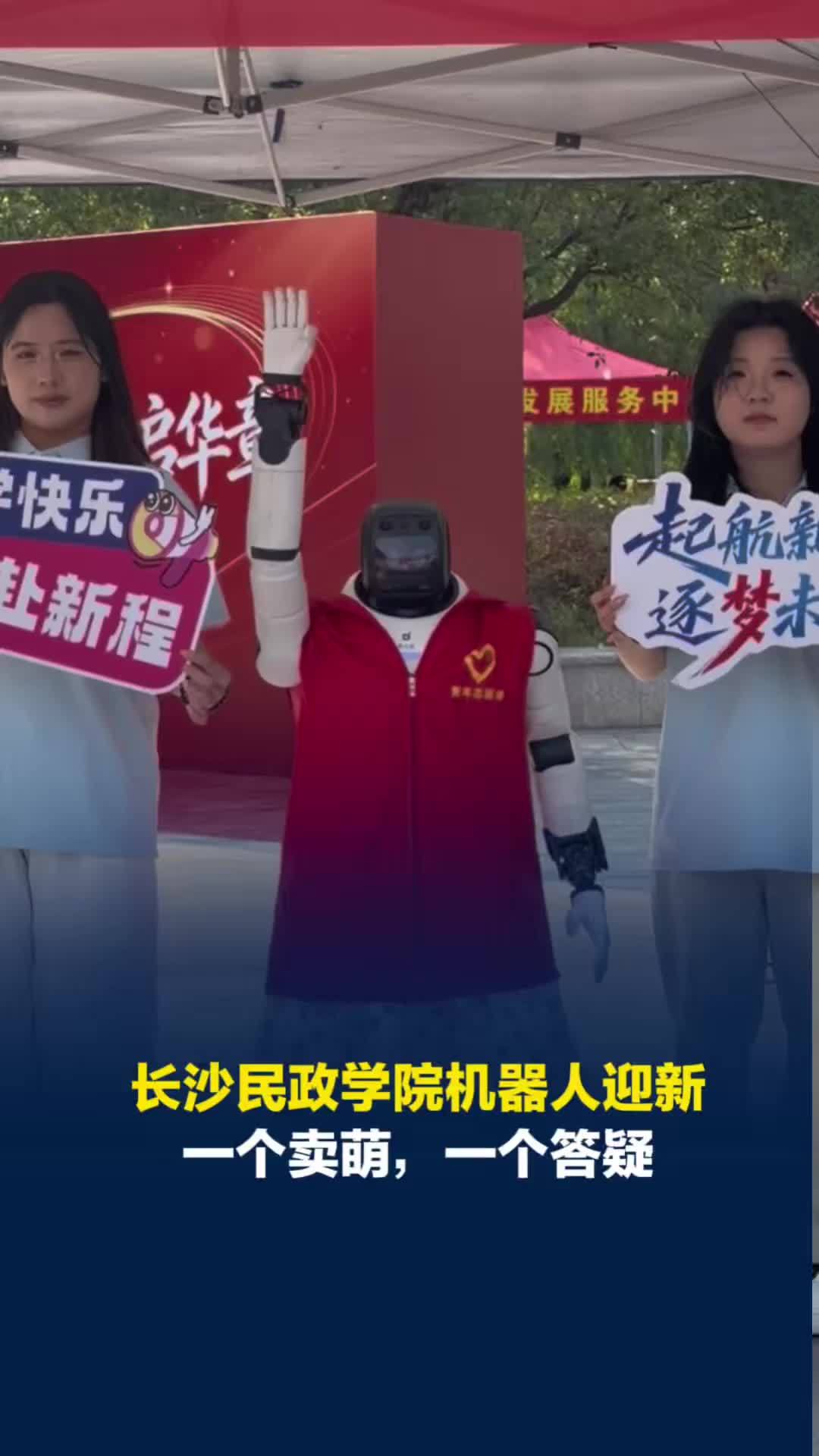 萌！俩机器人当起了迎新志愿者，一个穿碎花裙合影卖萌，一个“勤奋”答疑