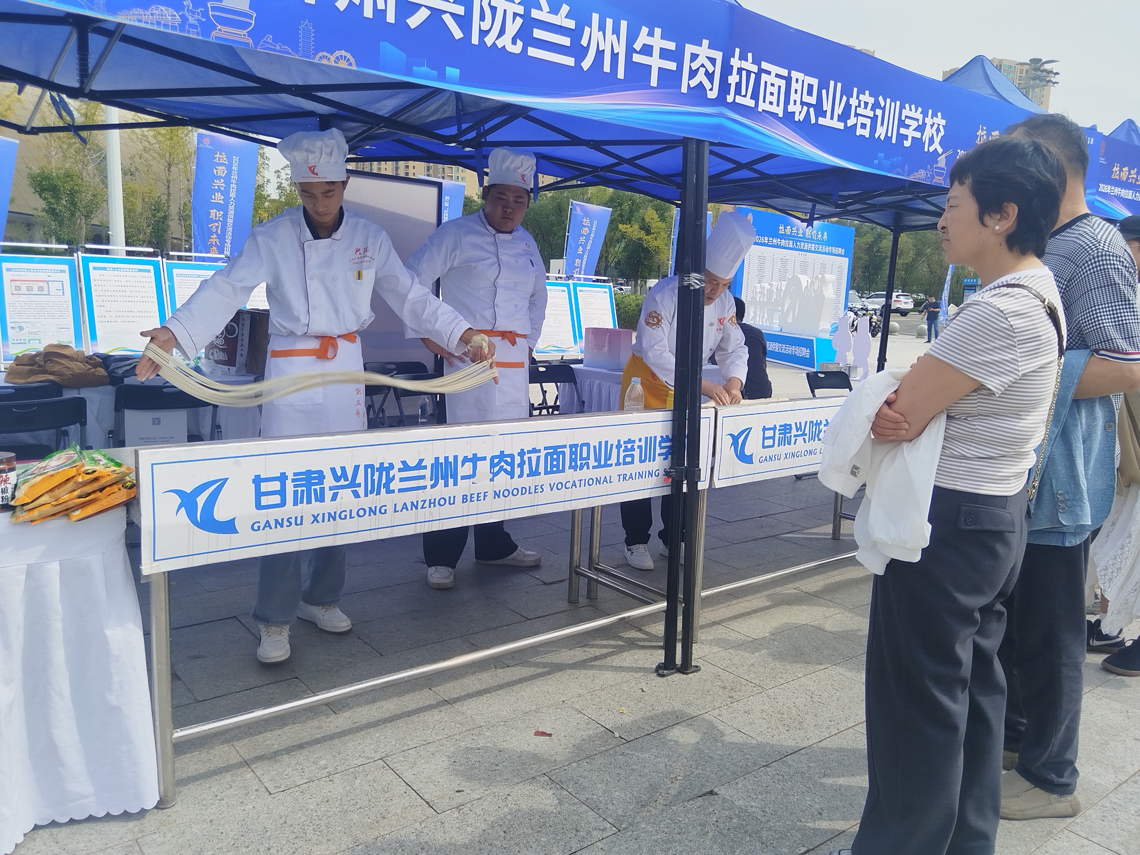 市民在一家牛肉拉面职业培训学校前驻足观看