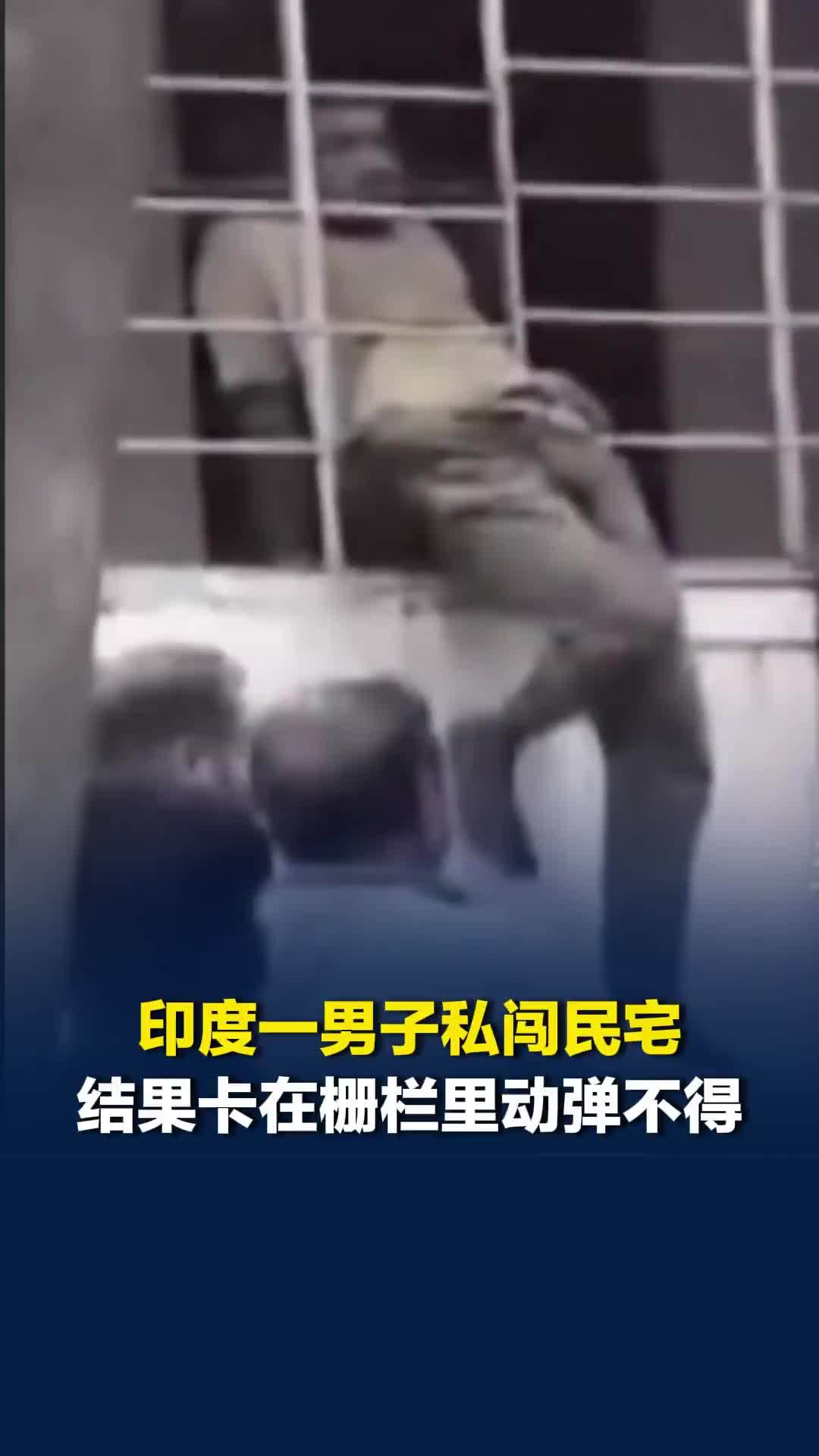 印度一男子私闯民宅，结果卡在栅栏里动弹不得，十分狼狈，围观群众愤怒殴打