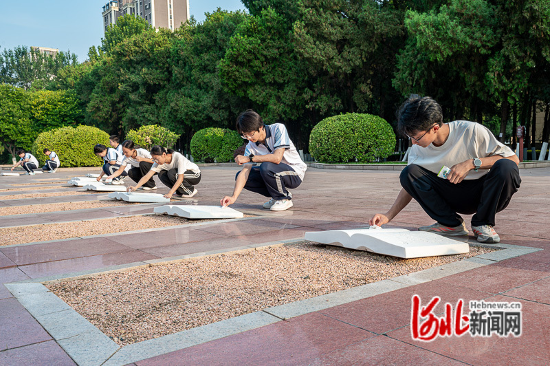 9月17日,唐山学院、唐山市开滦第二中学的学生擦拭冀东烈士陵园的烈士墓碑。河北日报记者郭宝强摄