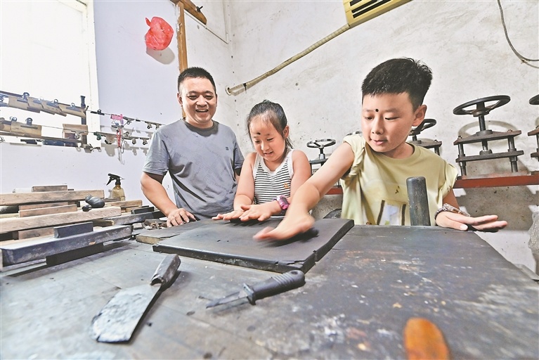 在浙源乡虹关村,省级非遗代表性传承人詹汪平指导研学的孩子们循古法完成收烟、和料、压模、晾干等十余道制墨工序。