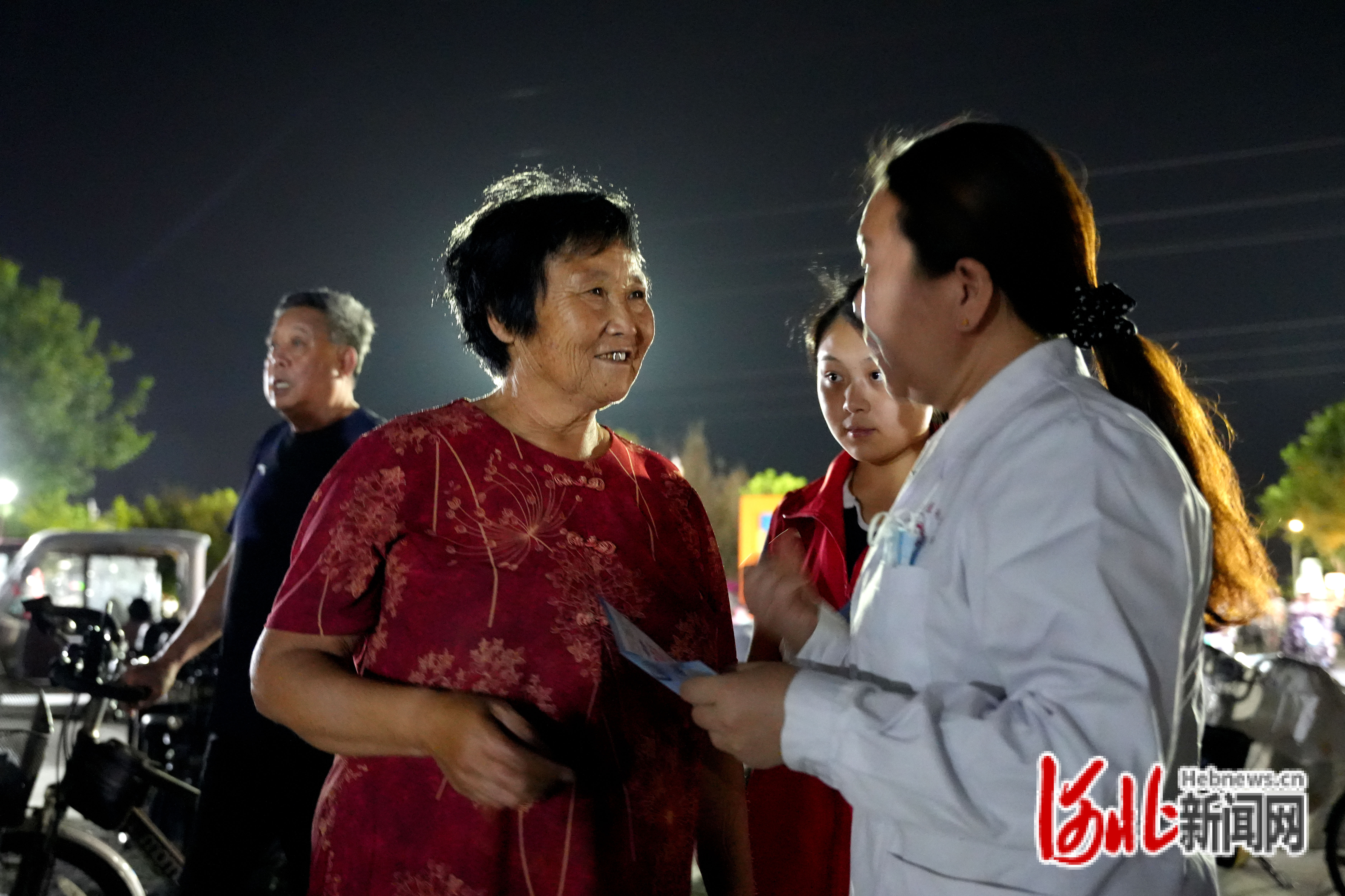 9月15日,河北省隆尧县园博园广场,医务人员正在向现场群众发放健康宣传手册。王雪摄