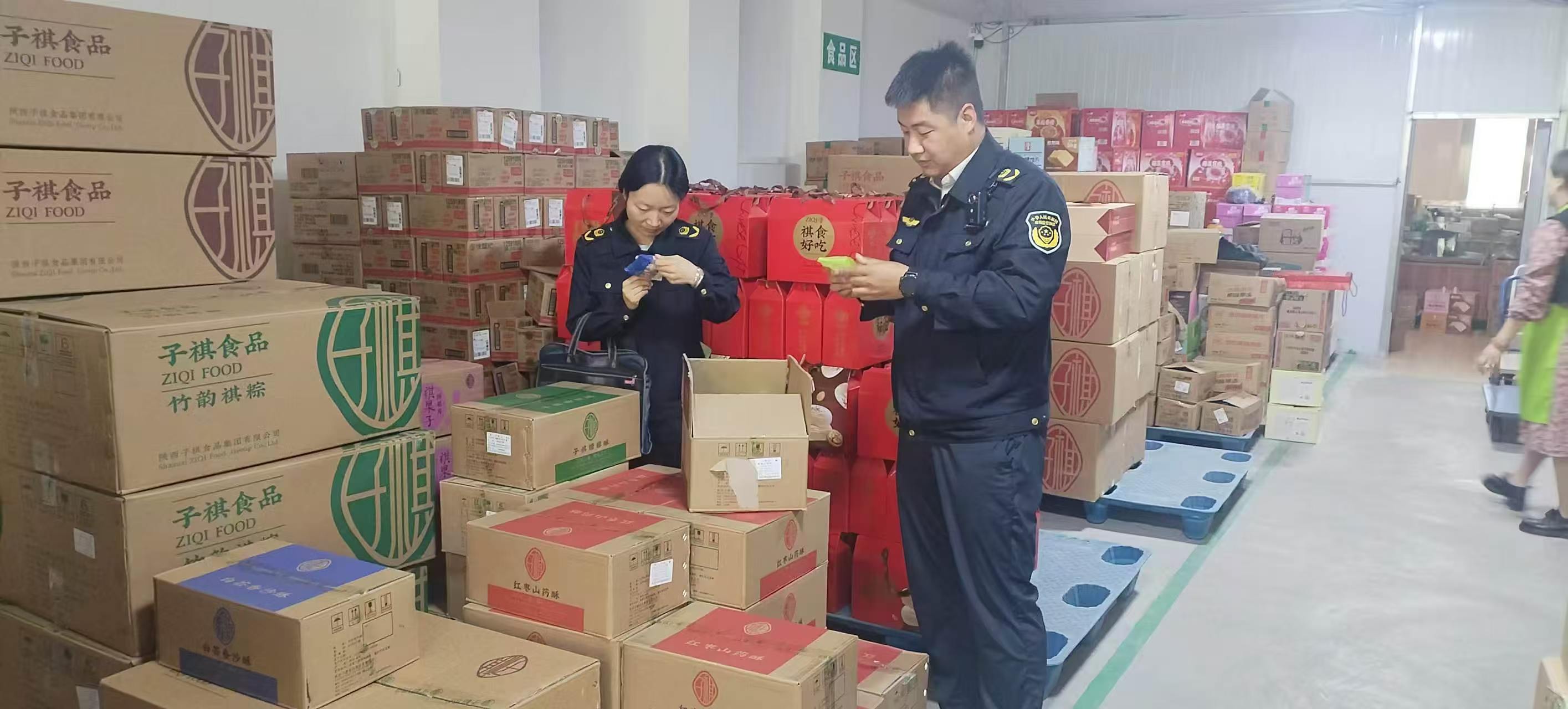 图为执法人员检查月饼生产日期和配料情况.jpg