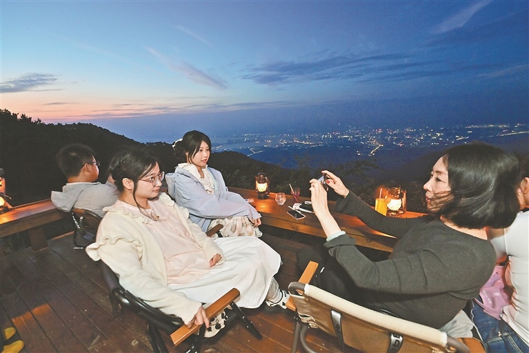 9月16日,游客在海拔1200米的“此山茶场”山顶拍照留念。